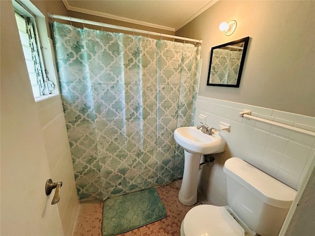 bathroom featuring tile walls, crown molding, curtained shower, and toilet