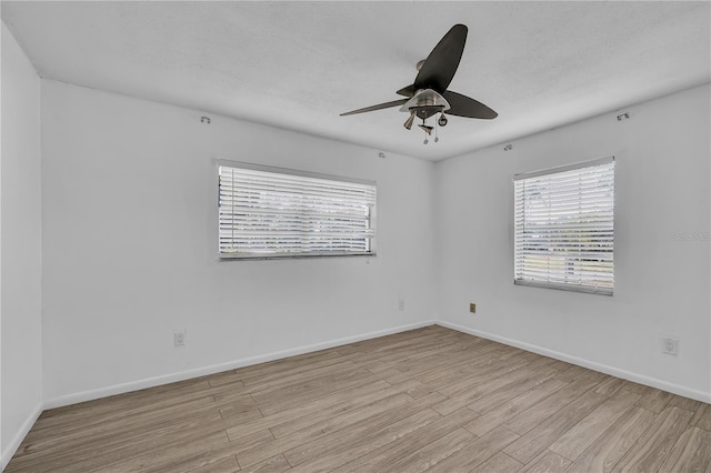 spare room featuring a textured ceiling, ceiling fan, and light wood-type flooring