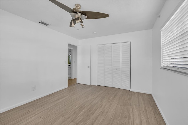 unfurnished bedroom with light hardwood / wood-style flooring, a closet, and ceiling fan