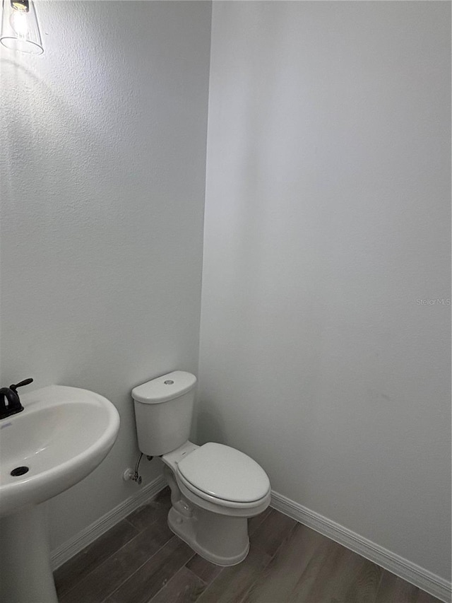 bathroom with hardwood / wood-style flooring, sink, and toilet