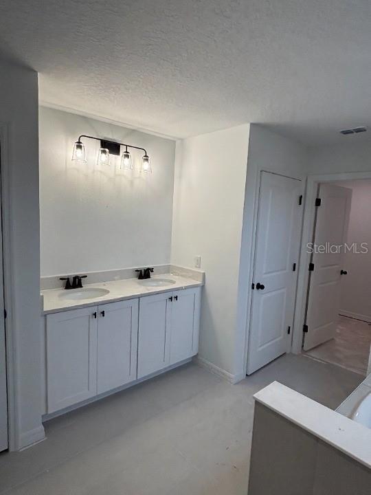 bathroom with vanity and a textured ceiling