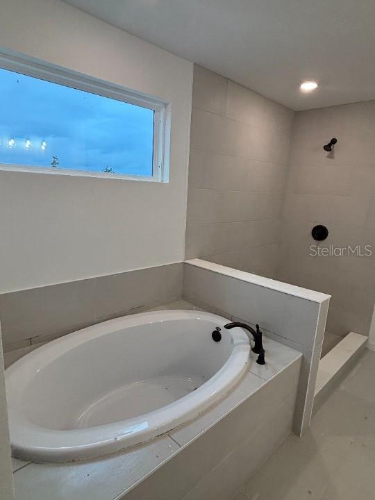 bathroom featuring shower with separate bathtub