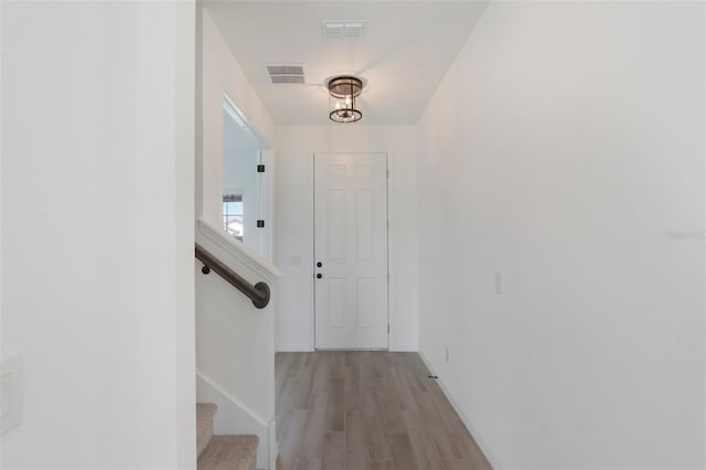 interior space with light wood-type flooring, visible vents, and stairway