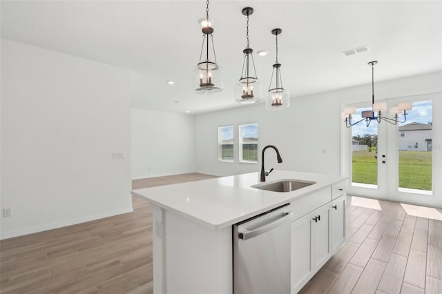 kitchen with dishwasher, light wood-style flooring, a sink, and visible vents