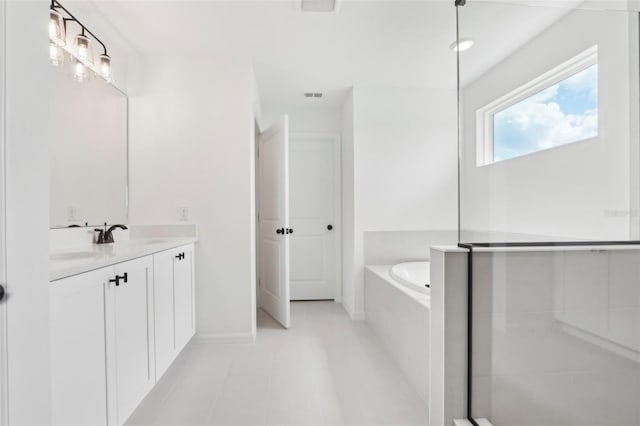 full bath featuring a bath, vanity, visible vents, and baseboards