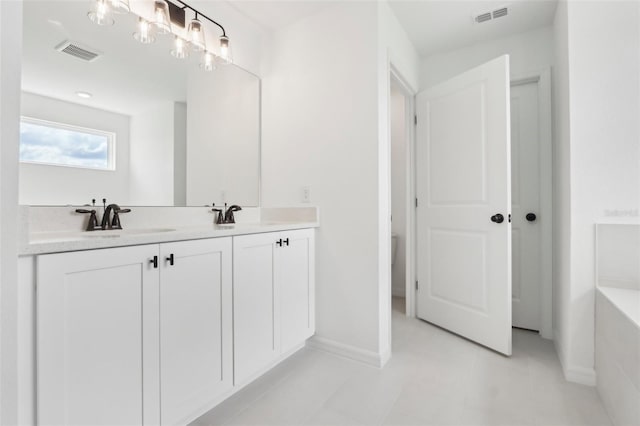 full bath with double vanity, a bathing tub, visible vents, and a sink