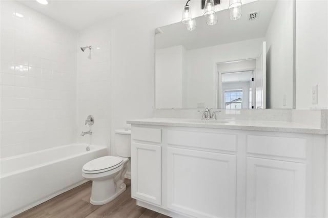 full bath with shower / tub combination, toilet, wood finished floors, visible vents, and vanity