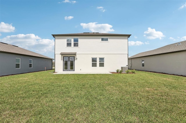 rear view of house featuring french doors, a lawn, and central air condition unit