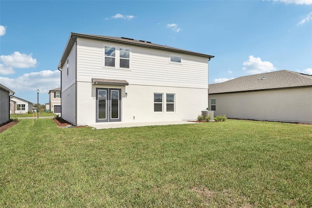 back of property featuring stucco siding, french doors, and a yard