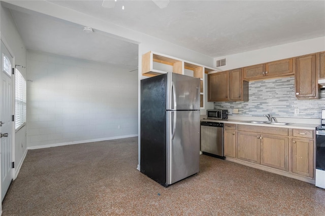 kitchen with appliances with stainless steel finishes, sink, and backsplash