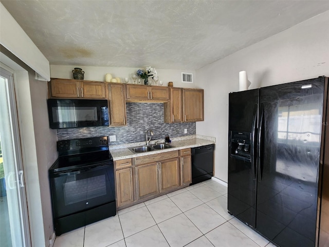 kitchen with sink, black appliances, light tile patterned floors, plenty of natural light, and backsplash