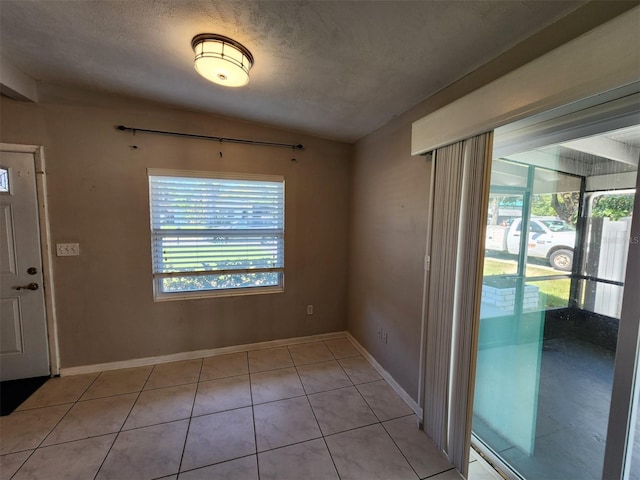 tiled entrance foyer with lofted ceiling and a textured ceiling