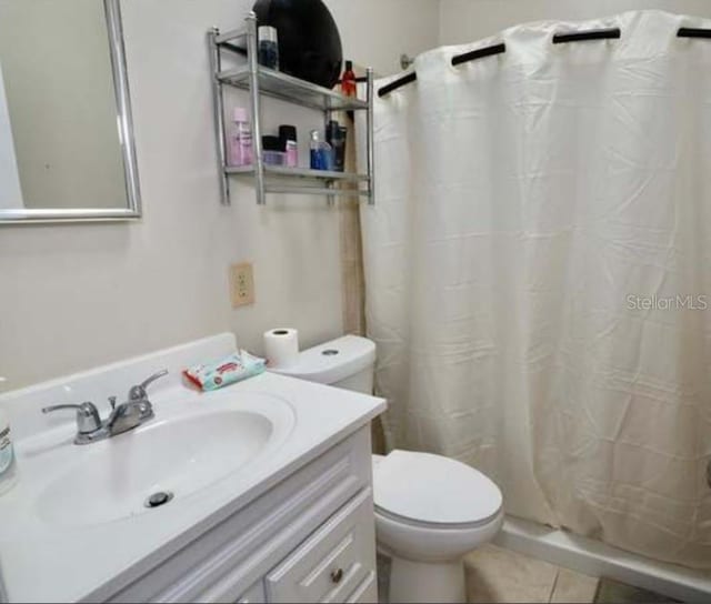 bathroom with vanity, tile patterned floors, toilet, and walk in shower