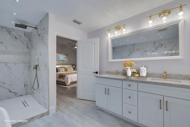 bathroom featuring vanity, tiled shower, and hardwood / wood-style floors