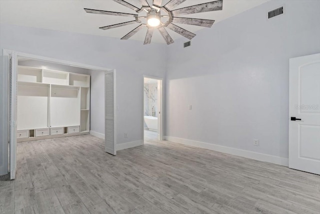 empty room with ceiling fan and light hardwood / wood-style floors