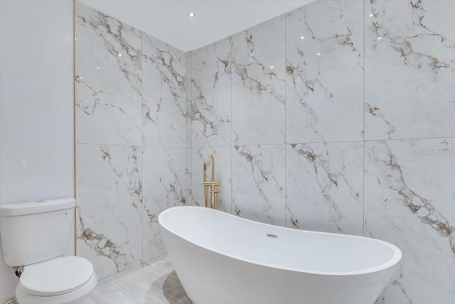 bathroom with a washtub and toilet