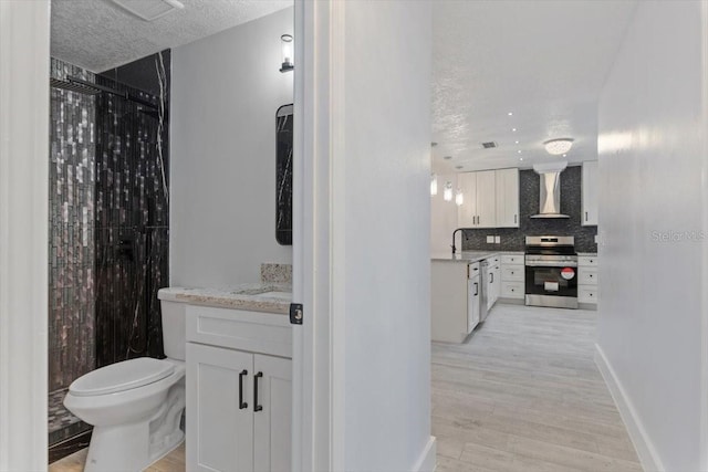 bathroom with vanity, toilet, hardwood / wood-style floors, and decorative backsplash