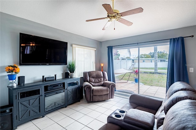 living room featuring light tile patterned floors, a textured ceiling, and ceiling fan