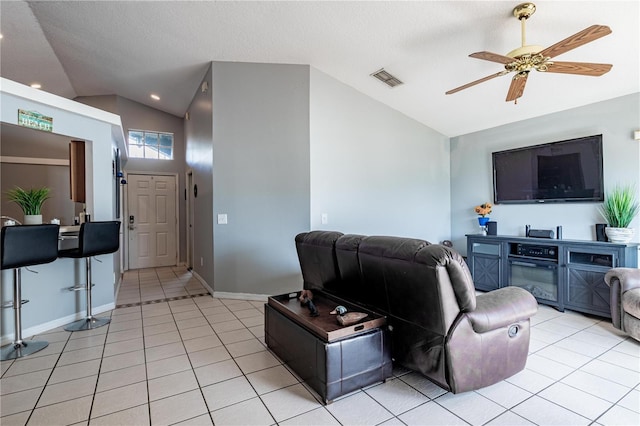 living room with lofted ceiling, light tile patterned floors, and ceiling fan