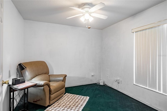 living area with ceiling fan and dark colored carpet