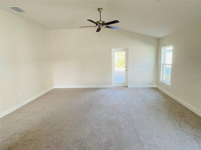 carpeted spare room featuring lofted ceiling and ceiling fan