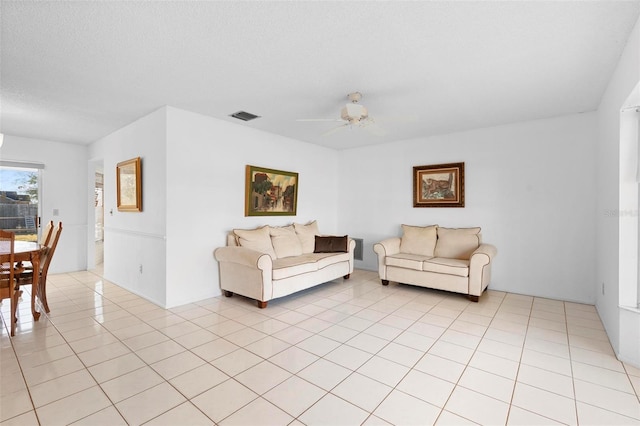 tiled living room with a textured ceiling and ceiling fan