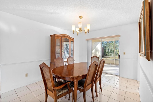 tiled dining space featuring an inviting chandelier and a textured ceiling