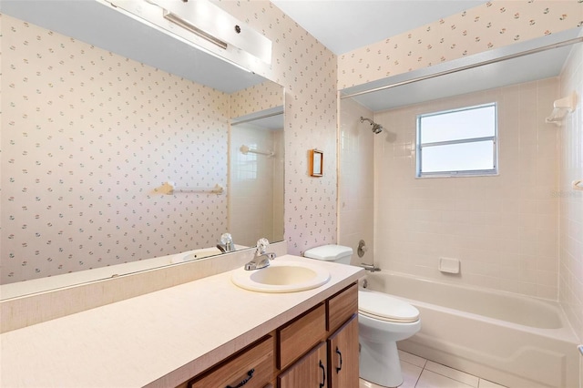 full bathroom featuring tile patterned flooring, vanity, tiled shower / bath combo, and toilet