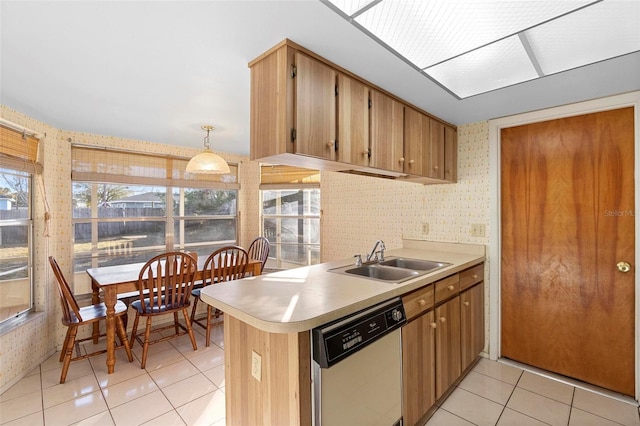 kitchen with decorative light fixtures, dishwasher, sink, light tile patterned floors, and kitchen peninsula