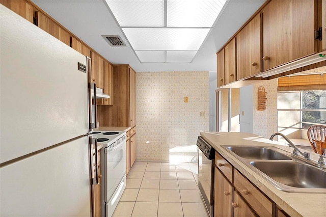 kitchen featuring white appliances, sink, and light tile patterned floors