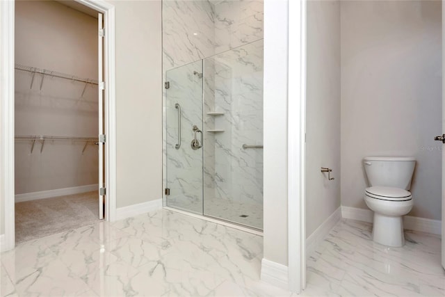 bathroom featuring a shower with door and toilet