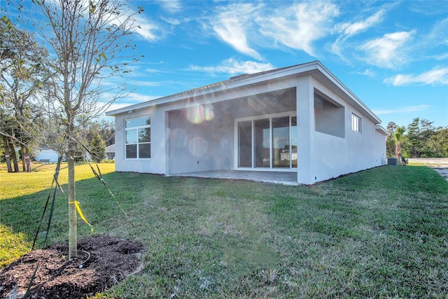 rear view of property with a yard and a patio area