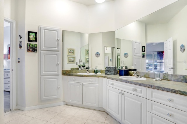 bathroom featuring a towering ceiling, tile patterned floors, and vanity