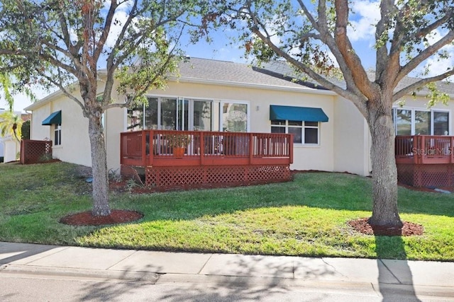 view of front facade with a wooden deck and a front lawn