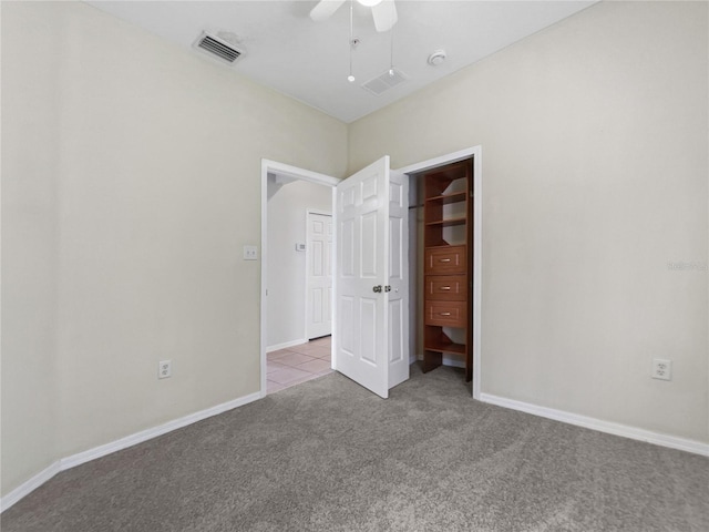 unfurnished bedroom featuring light carpet, a closet, and ceiling fan