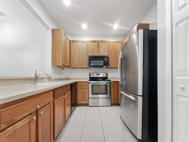 kitchen featuring light tile patterned floors, sink, and black appliances