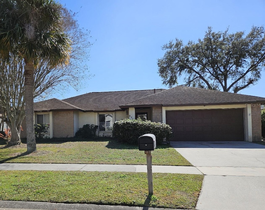 ranch-style home featuring a garage and a front yard