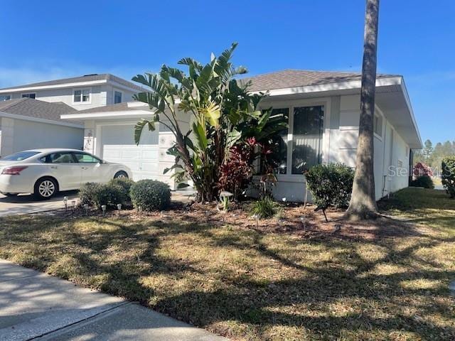 view of front of house with a garage and a front lawn