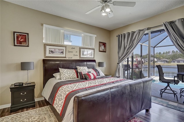 bedroom with dark hardwood / wood-style floors, multiple windows, and access to outside