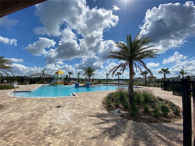 view of pool featuring a patio and a playground