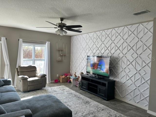 living room featuring ceiling fan and a textured ceiling