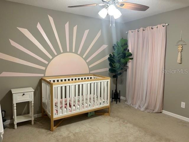 carpeted bedroom featuring a nursery area, ceiling fan, and vaulted ceiling