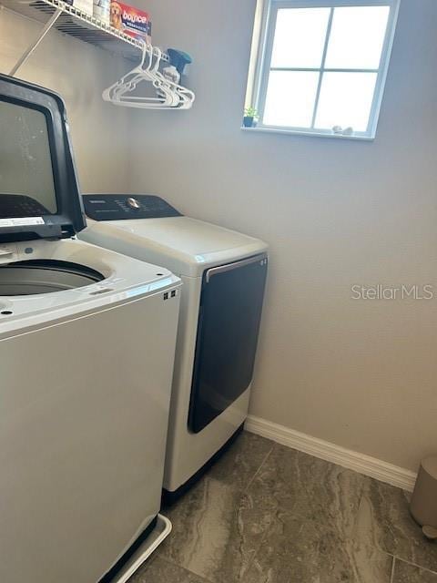 clothes washing area with washer and clothes dryer