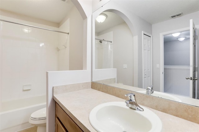 full bathroom with vanity, shower / tub combo, a textured ceiling, and toilet