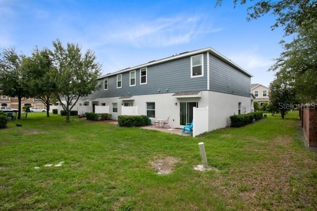 rear view of property featuring a patio and a lawn