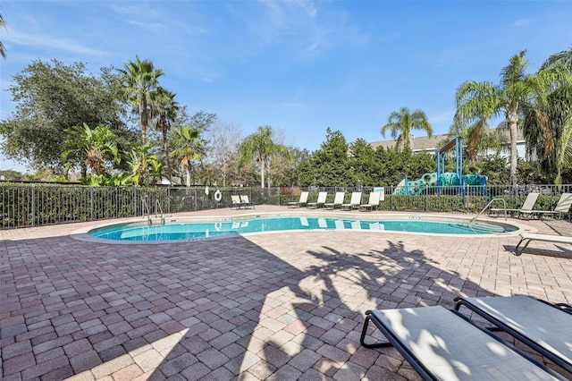 view of swimming pool featuring a playground and a patio area