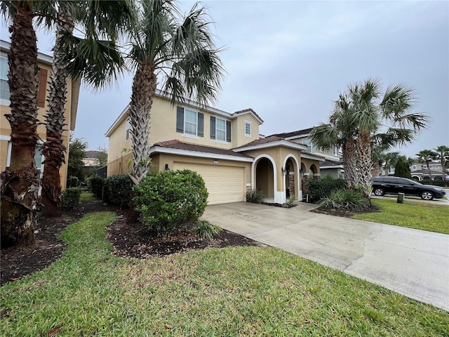 mediterranean / spanish-style home featuring a garage and a front yard