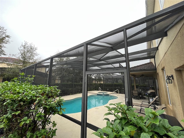 view of swimming pool with a lanai, a patio area, and an in ground hot tub