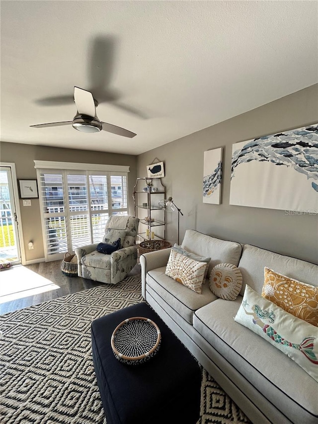 living room with ceiling fan, a textured ceiling, wood-type flooring, and a healthy amount of sunlight