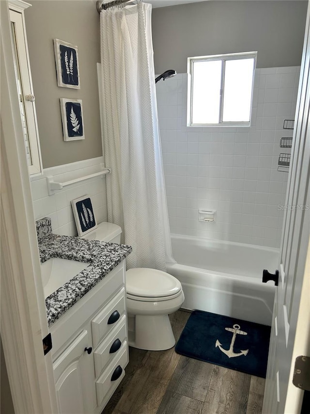 full bathroom with toilet, tile walls, vanity, shower / bath combination with curtain, and hardwood / wood-style floors